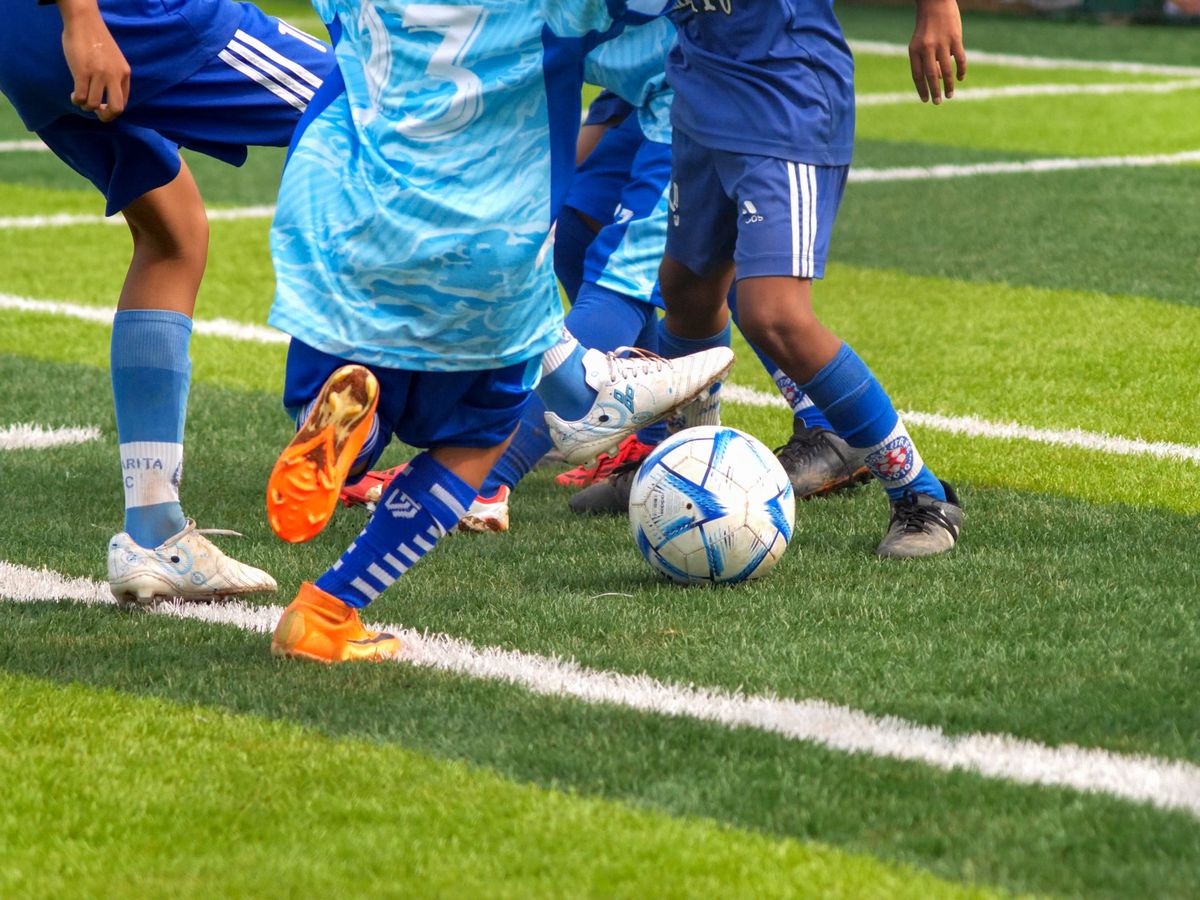 Jóvenes deportistas jugando fútbol en una cancha